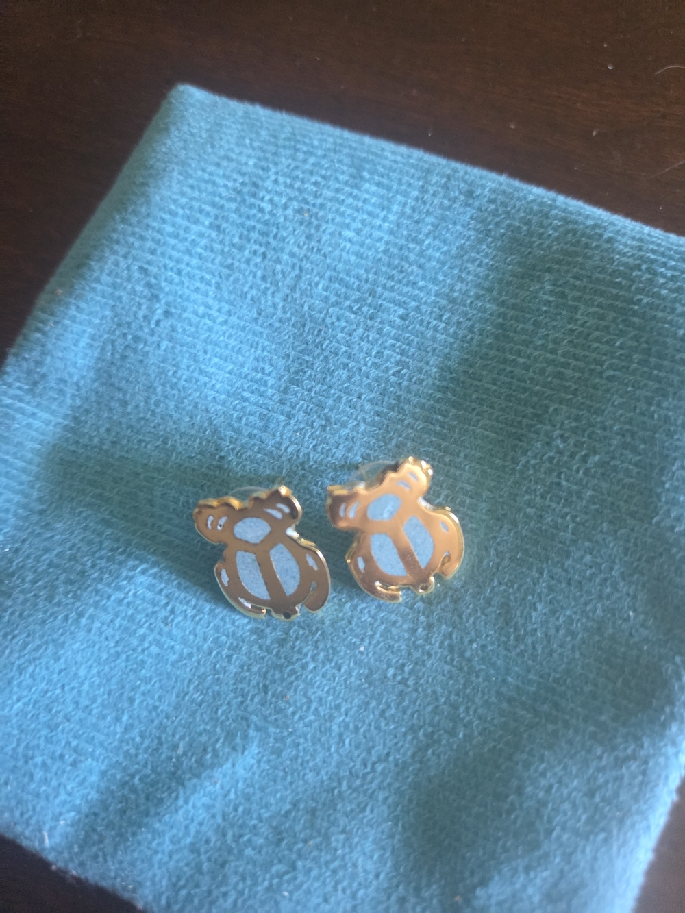 Gold Turtle Stud Earrings on Turquoise Cloth